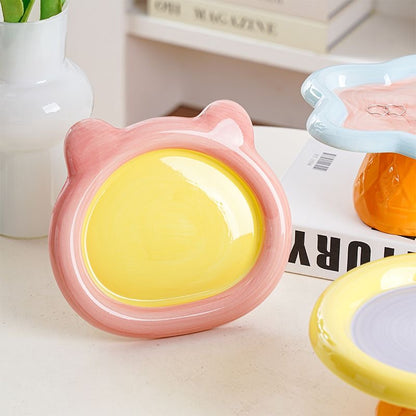Close-up of the glossy pink and yellow Teddy Bear elevated cat bowl. Crafted from premium, non-porous ceramic that naturally resists bacteria and prevents feline chin acne.