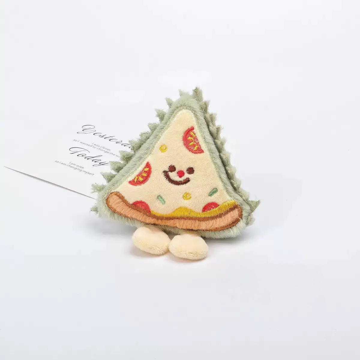 A quirky green durian slice plush toy with textured "spikes" and a smiling face, perfect for sensory play.