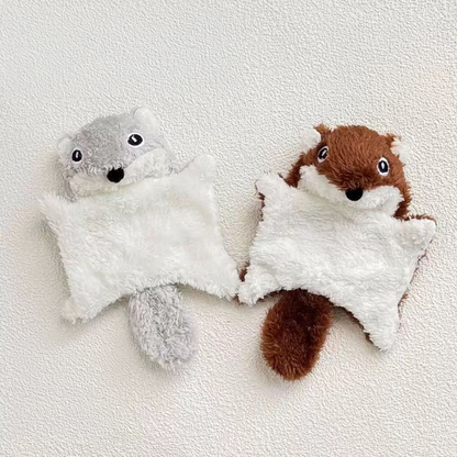 Two plush flying squirrel pet toys, one in grey and one in brown, lying flat side-by-side on a textured white surface to showcase the adorable woodland color options.