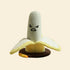 Front view of the hilarious Banana Cat Scratching Post featuring a grumpy embroidered face, hand-woven sisal rope, and soft plush petals folded down over a heavy-duty brown base.