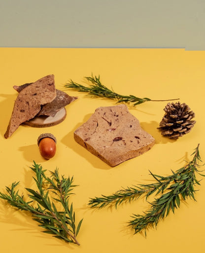 Multiple Lamb Liver chips on a yellow table, grain-free and hypoallergenic treats made in Australia.