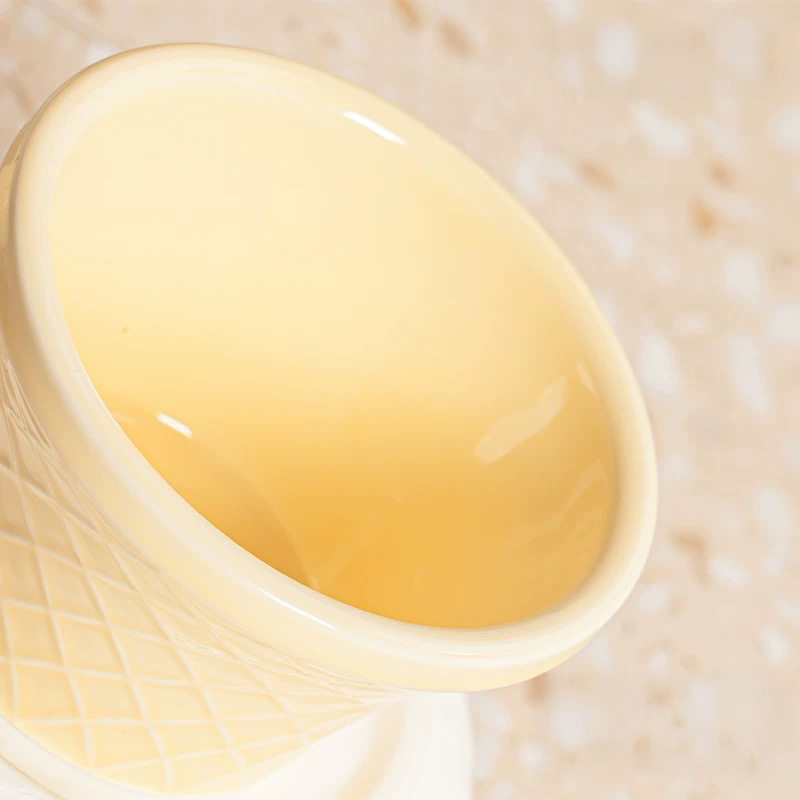 Interior detail of the yellow ceramic bowl, showing the spiral design and smooth, deep finish for wet food or water