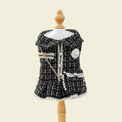 Front view of the black tweed pet dress on a mannequin. Shows the classic collar, pearl button snaps, and premium textured fabric for a high-fashion look