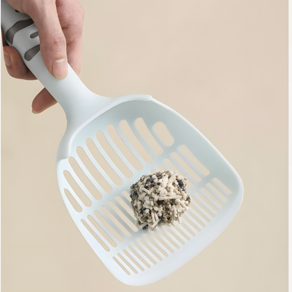 Hand holding the blue scoop filled with a mixed litter clump. Demonstrates the triple-filter design that traps waste without wasting clean litter.