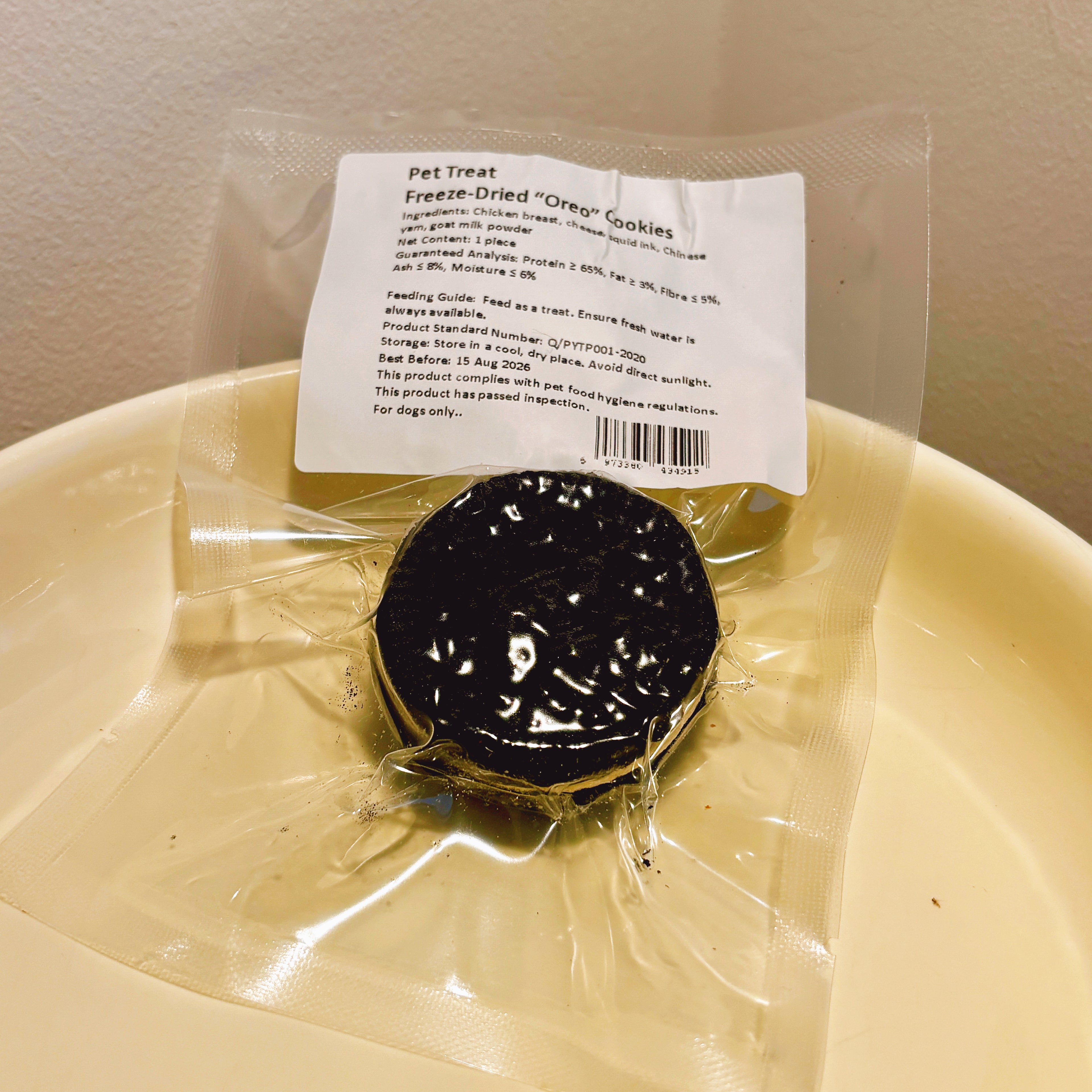 Individually sealed freeze-dried dog cookie pouch, showing natural ingredients like chicken breast, squid ink, and Chinese yam.