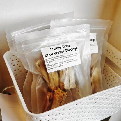 Multiple packs of duck cartilage treats in a white basket, ideal for dogs with skin allergies or those needing a "cooling" protein source.