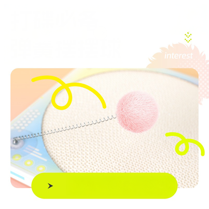 Close-up of the spring-loaded pom-pom teaser on the DJ cat scratcher. Designed for solo play and to spark the cat&