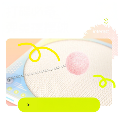 Close-up of the spring-loaded pom-pom teaser on the DJ cat scratcher. Designed for solo play and to spark the cat&
