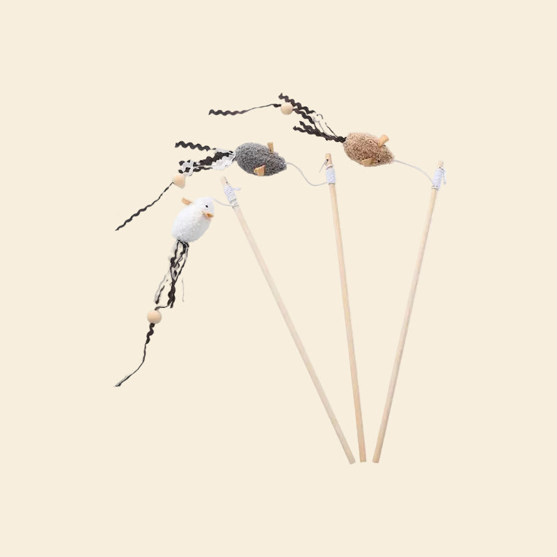 Three LéJoyee natural wood cat teaser wands floating in the air, featuring plush mice in white, grey, and brown, with long zig-zag crinkle ribbon tails and wooden beads attached to bouncy elastic strings.