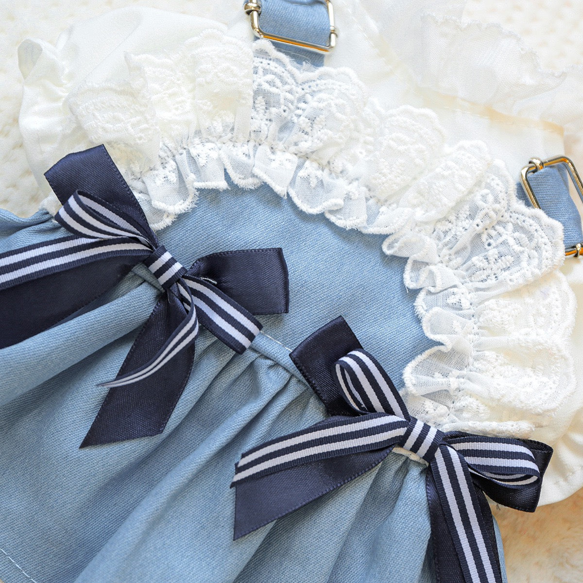 Macro shot of the navy and white striped satin bows and delicate lace ruffles. The sensory-soft fabric ensures comfort for pets while providing a chic maritime vibe