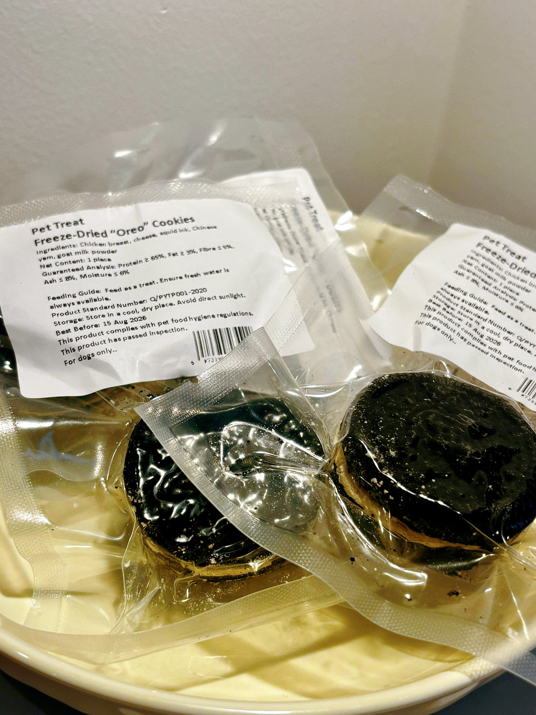 Multiple freeze-dried "Oreo" style dog cookies in a bowl, a healthy high-value reward that looks like human snacks.