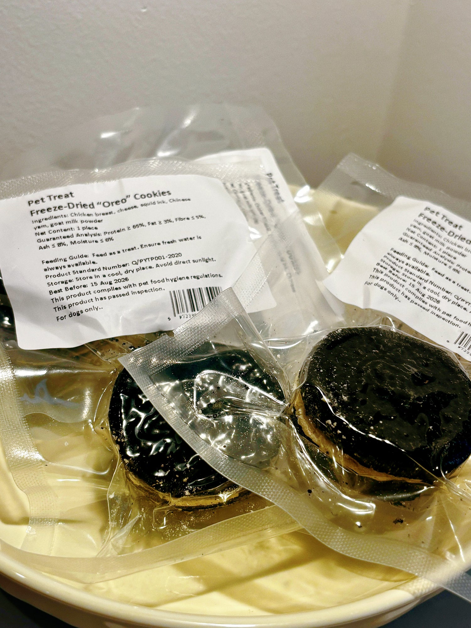 Multiple freeze-dried "Oreo" style dog cookies in a bowl, a healthy high-value reward that looks like human snacks.