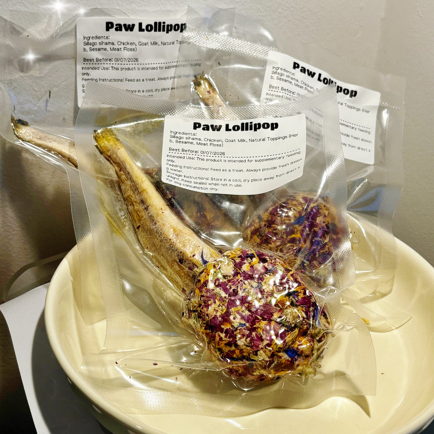 Collection of individually wrapped Paw Lollipops in a plate, showing the premium chicken and goat milk base with varied gourmet toppings.