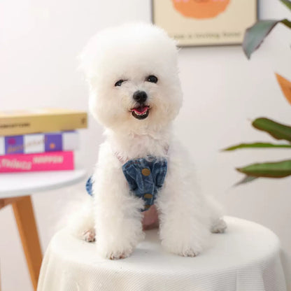 Front view of a white dog wearing the denim vest dress. Equipped with sturdy belly-side snap buttons for stress-free changes and a comfortable fit."