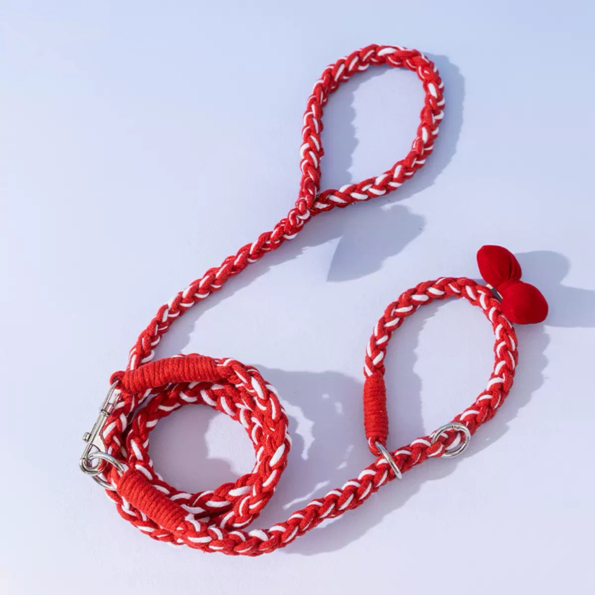 Hand holding the red braided leash. The ergonoåmic loop handle prevents hand fatigue during long walks