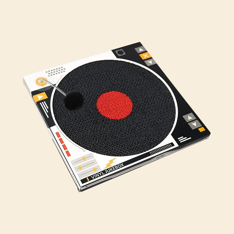 Angled view of the record-shaped cat scratch pad. Features a spring-loaded pom-pom ball that mimics prey to keep cats engaged and active