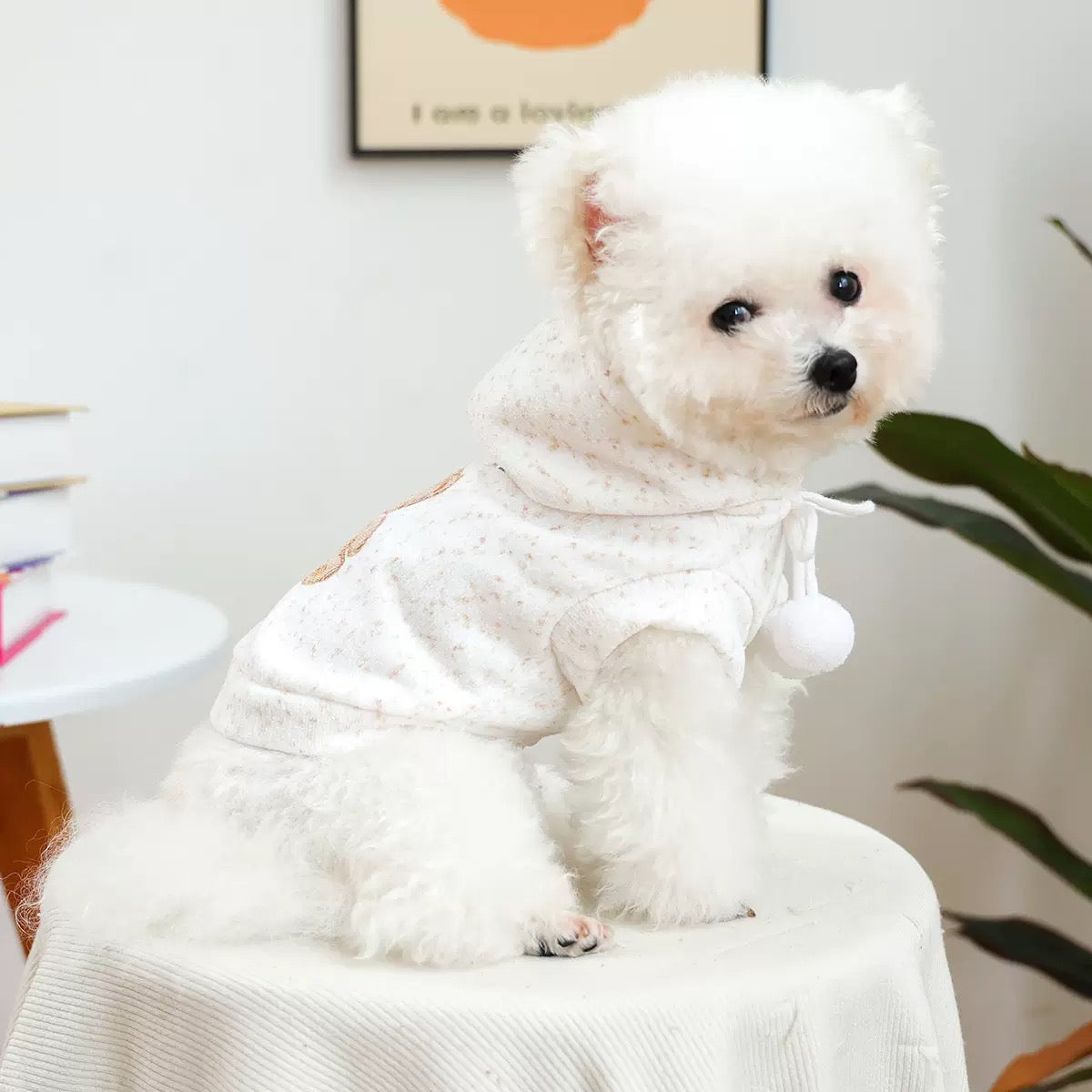 Side profile of a dog in the cream speckled hoodie. The sleeveless design and large armholes allow for a full range of motion during outdoor play