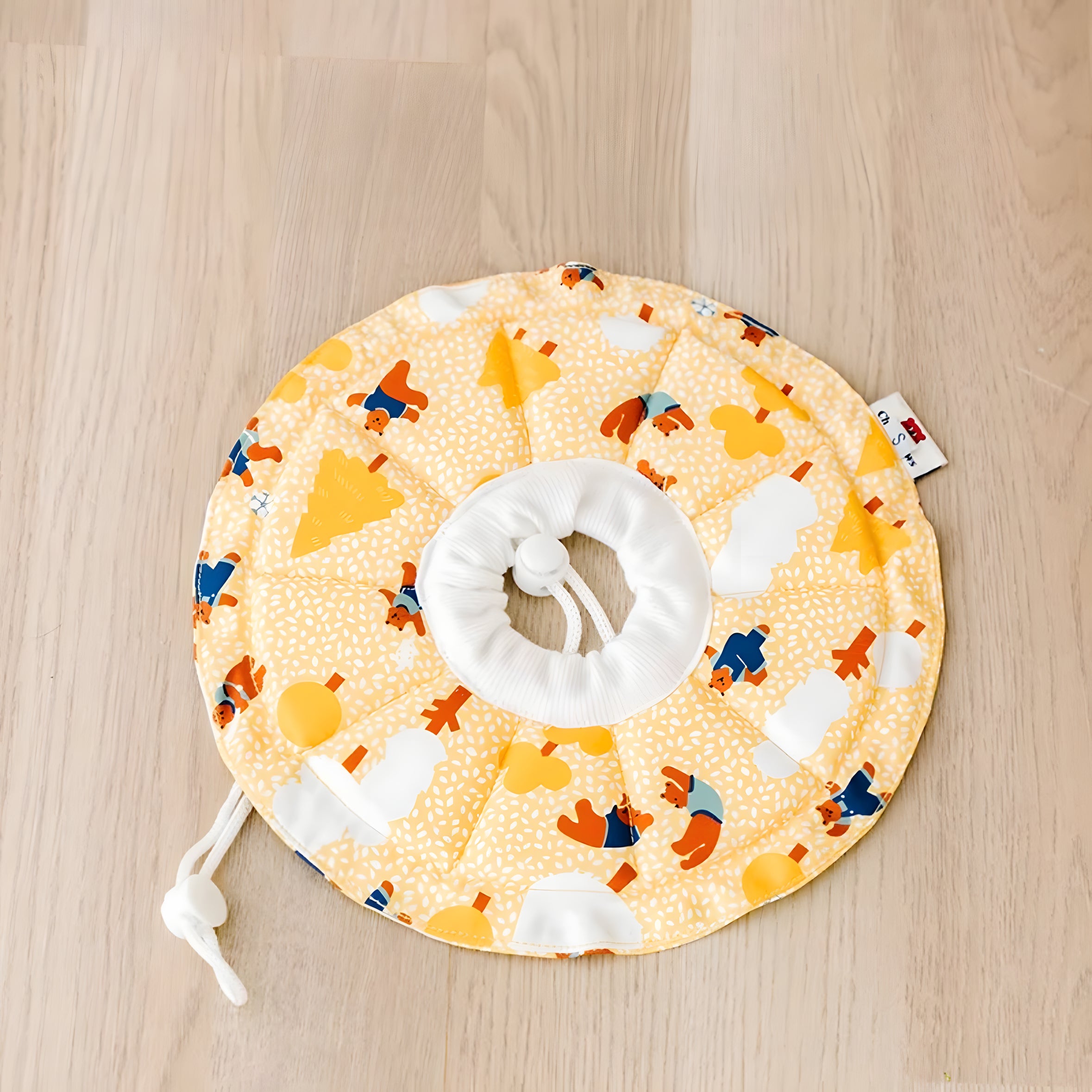 Yellow soft Elizabeth collar featuring a bear and tree pattern. The waterproof fabric prevents wet food messes during mealtime