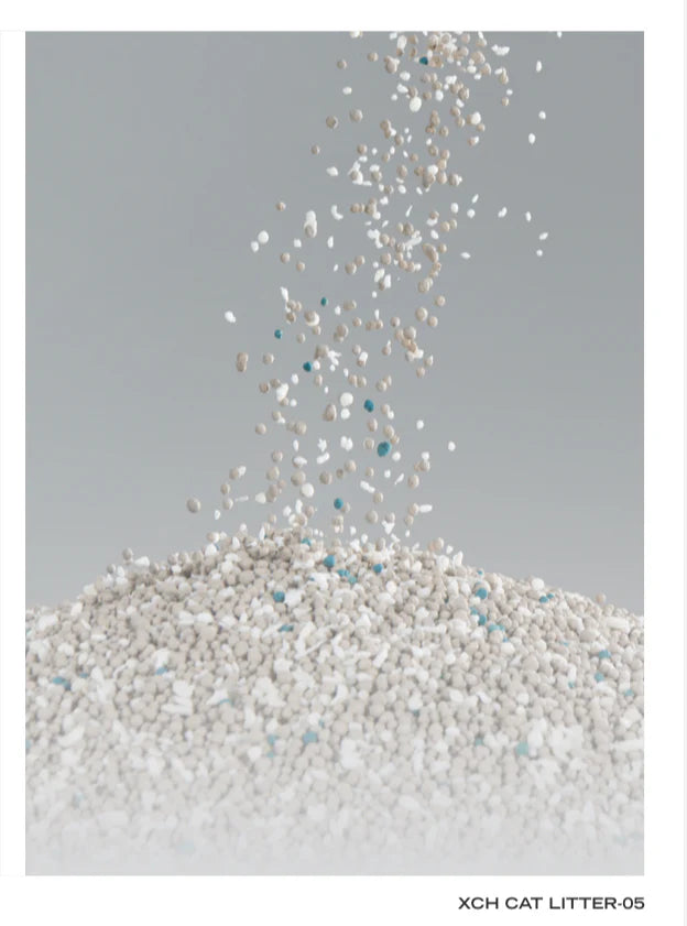A close-up of Xu Cuihua mixed cat litter granules falling into a pile, showcasing the fine, paw-friendly blend of corn starch, sodium bentonite clay, and visible blue deodorising granules.