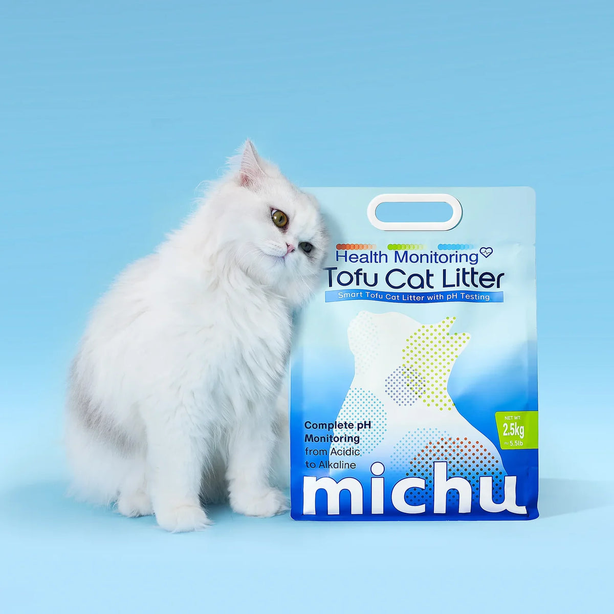 Fluffy white longhair cat sitting next to a bag of Michu health monitoring tofu cat litter against a sky-blue background.