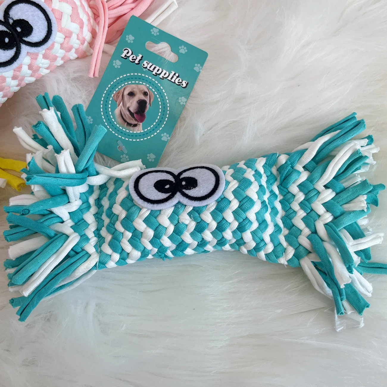 The mint teal blue variant of the Woven Candy Squeaky Toy. It highlights the unique woven fabric strips, the charming wrapped candy design, and the built-in squeaker.