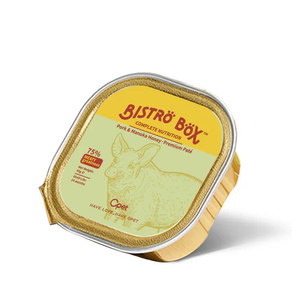 An angled view of a single 40g gold foil tray of OPET Bistro Box Wet Cat Food. The yellow and green label features a pig illustration and highlights "Pork &amp; Manuka Honey Premium Pâté" and "75% Meaty Greatness."
