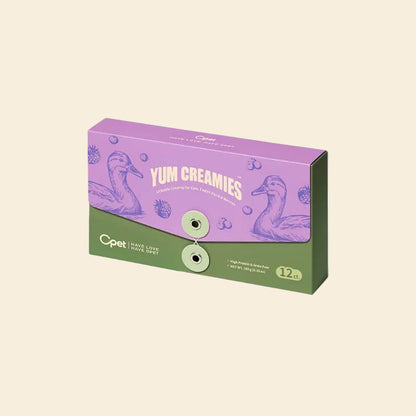 A purple and green 12-pack box of OPET Yum Creamies lickable cat treats in Duck &amp; Berries flavor, featuring a vintage illustration of a duck and fresh berries.