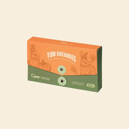 An orange and green 12-pack box of OPET Yum Creamies lickable cat treats in Rabbit &amp; Pumpkin flavor, featuring vintage illustrations of a rabbit and pumpkins.