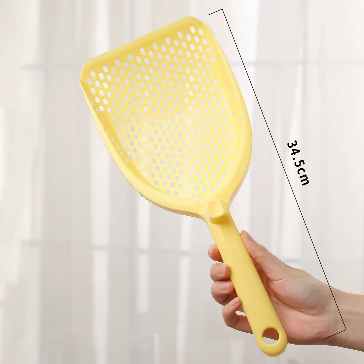 Hand holding the Premium Round-Hole Cat Litter Scoop in Soft Yellow, highlighting the generous 34.5cm total length and 14.5cm wide shovel head for comfortable scooping.