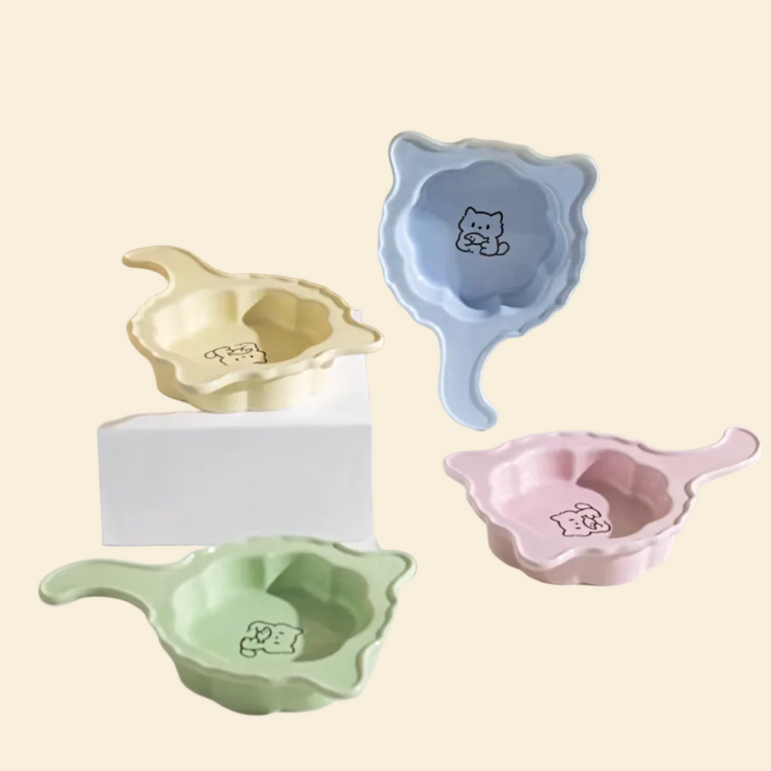 A beautiful collection of all four pastel Crooked Tail ceramic pet plates in Soft Pink, Baby Blue, Mint Green, and Butter Yellow, styled together.