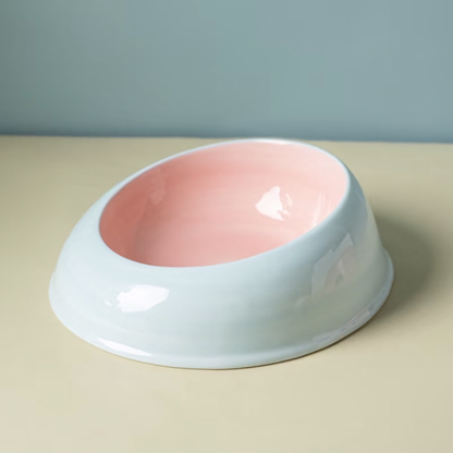 Close-up of the Milk Candy ceramic cat bowl featuring a sweet two-tone pastel pink exterior and powder blue interior. Wide, whisker-friendly design for stress-free meals.