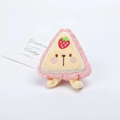 Close-up of a pink plush strawberry toy with an embroidered face and green leaf, safe for small dogs and cats.