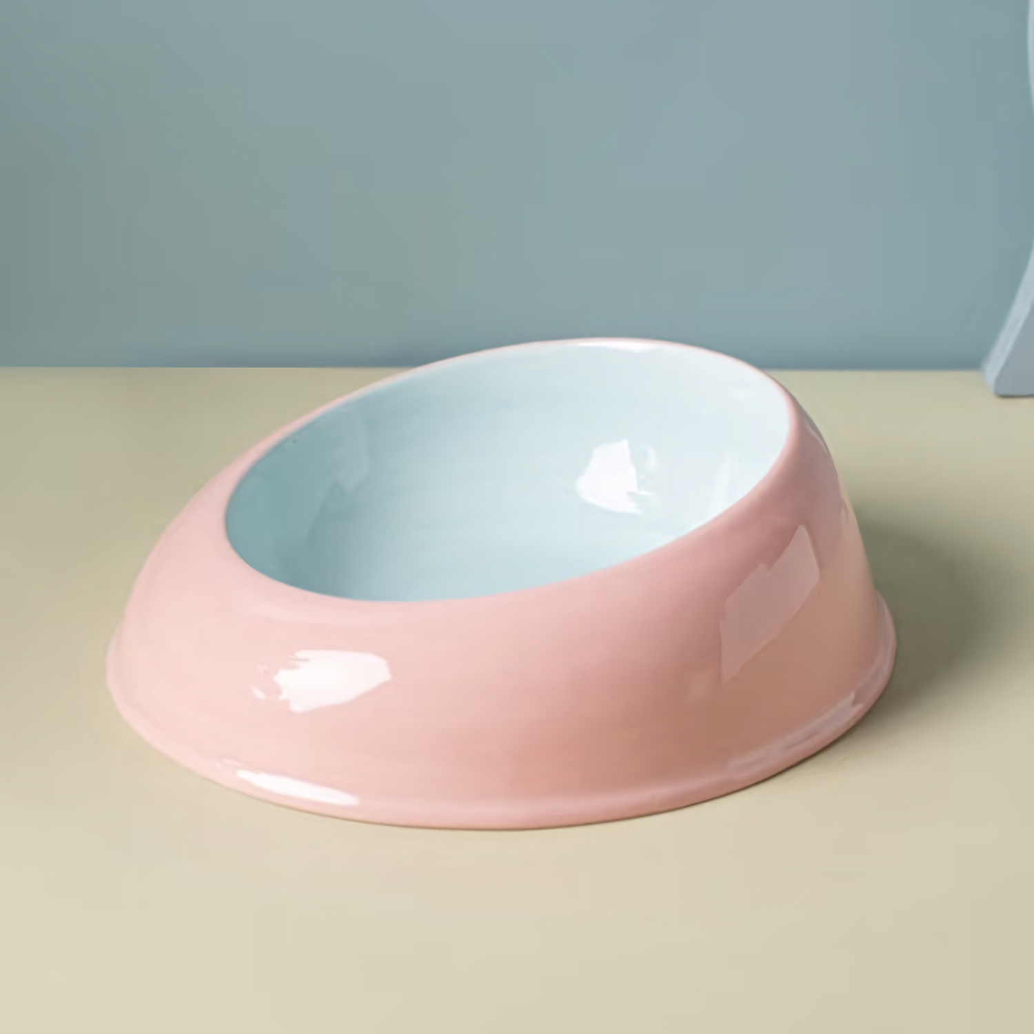 The ultra-glossy Milk Candy ceramic cat feeding dish with a powder blue exterior and soft pink interior, resting on a clean pastel surface.