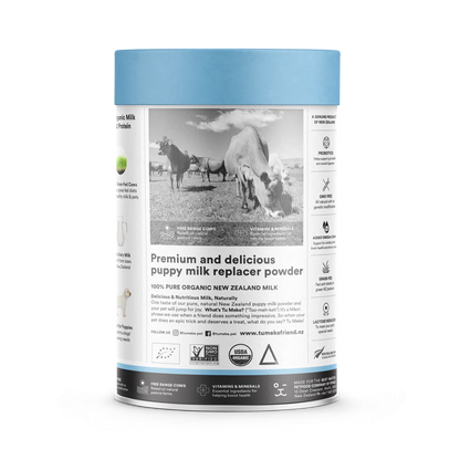 Side view of the TU MEKE FRIEND puppy milk replacer canister, showing a black and white photo of grass-fed cows in a pasture, along with icons highlighting Probiotics, GMO-free ingredients, added Omega-3 DHA, and reduced lactose.