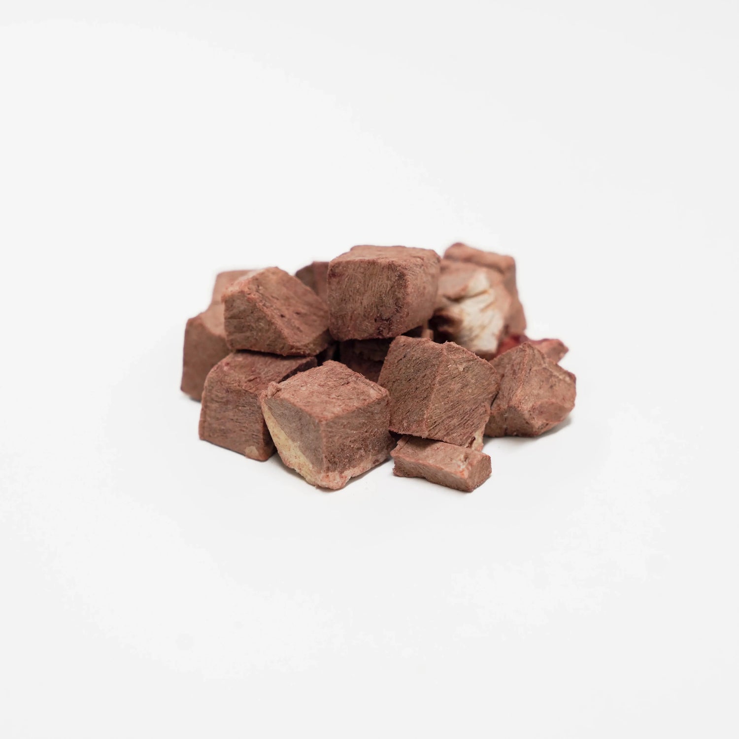 A close-up of RAFA raw freeze-dried Australian beef heart cubes on a white background, highlighting the dense meat texture and 80% protein raw goodness.