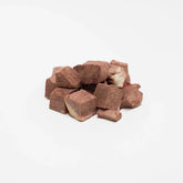 A close-up of RAFA raw freeze-dried Australian beef heart cubes on a white background, highlighting the dense meat texture and 80% protein raw goodness.