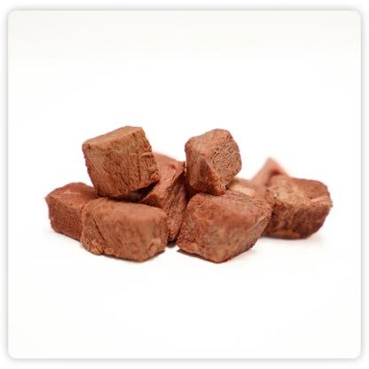 A close-up of RAFA raw freeze-dried Australian beef steak cubes on a white background, highlighting the thick, meaty texture and rich, bold flavor.