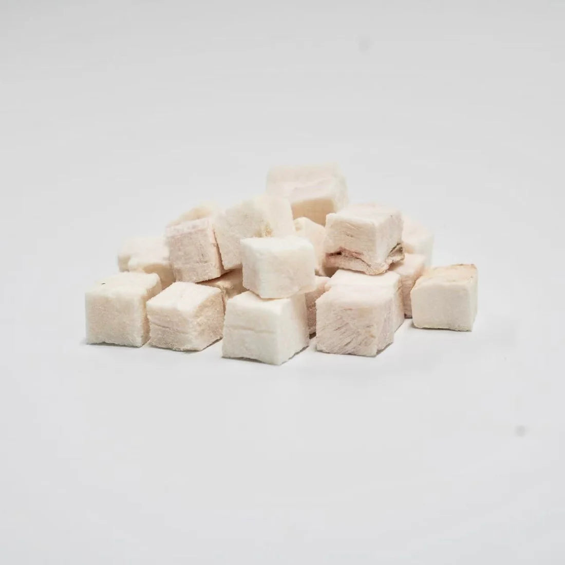 A close-up of RAFA raw freeze-dried New Zealand Pink Ling cubes on a white background, highlighting the pure, flaky white fish texture of this low-fat, high-protein seafood treat.