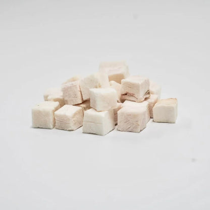 A close-up of RAFA raw freeze-dried New Zealand Pink Ling cubes on a white background, highlighting the pure, flaky white fish texture of this low-fat, high-protein seafood treat.
