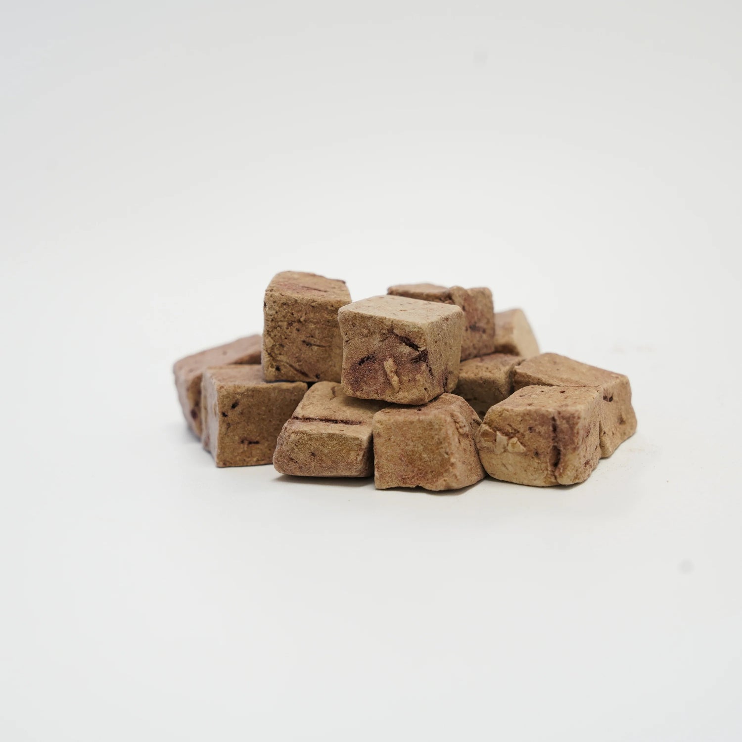 A close-up of RAFA raw freeze-dried Australian lamb liver cubes on a white background, highlighting the pure, nutrient-dense texture of nature&