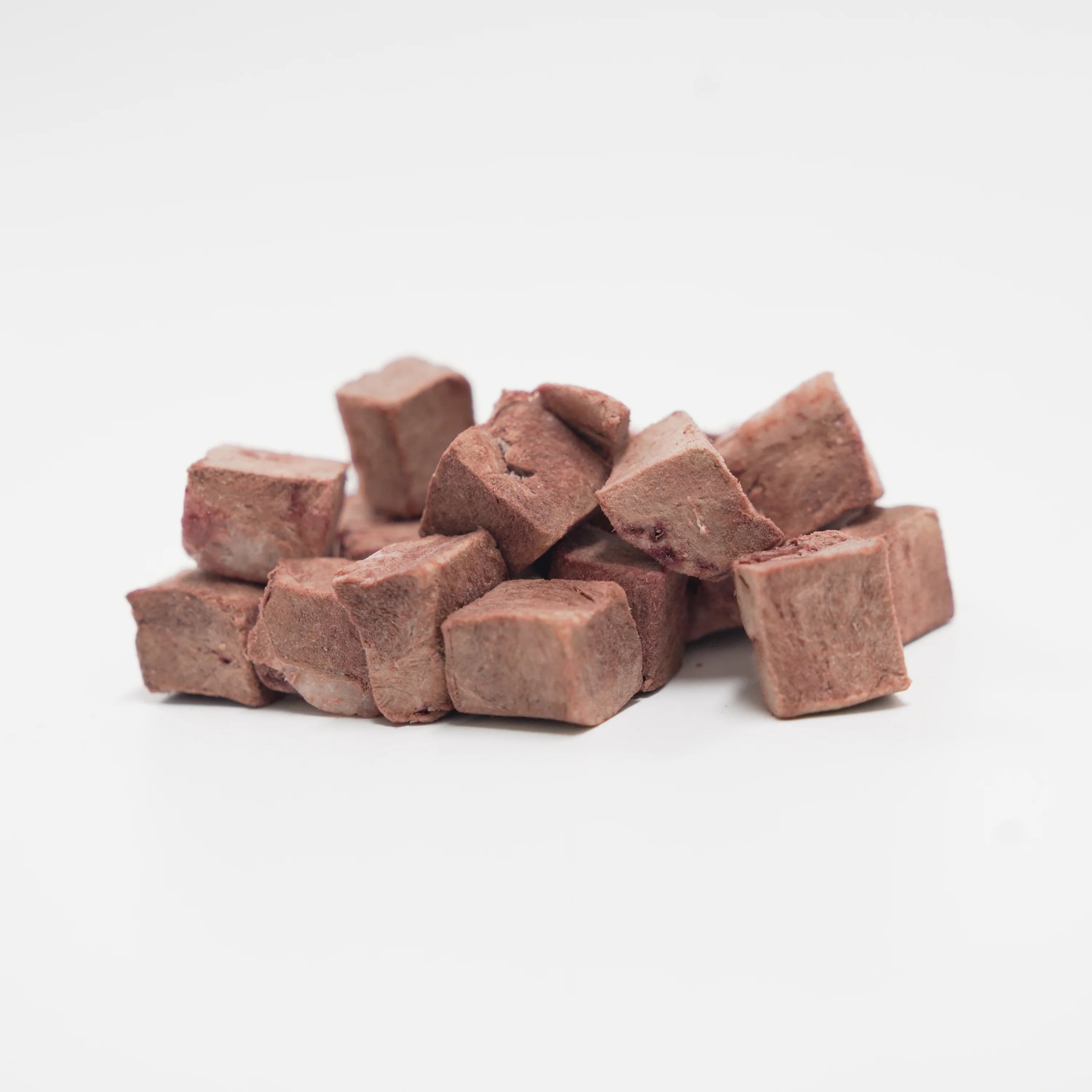 A close-up pile of RAFA raw freeze-dried Australian lamb heart cubes on a white background, showcasing the pure, single-ingredient texture and nutrient-dense raw goodness.