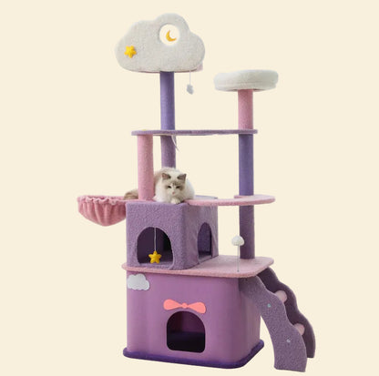 A Ragdoll cat resting comfortably in the pink plush side basket of the tall, multi-level Tales of the Nebula Cat Tree.