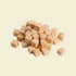 A close-up view of portion-controlled freeze-dried salmon cubes piled on a white background, highlighting their natural texture and Omega-3 rich formula.