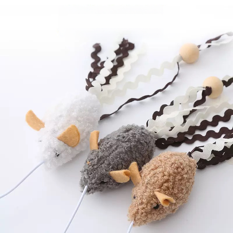 Close-up of three ultra-soft fleece plush mouse cat toys in white, grey, and brown with felt ears, showing the attached flowing clusters of zig-zag ric-rac ribbons and natural wooden beads.