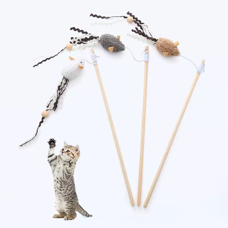 A cute tabby kitten standing on its hind legs reaching up to catch three floating plush mouse teaser wands, demonstrating the erratic bounce that triggers deep-rooted hunting instincts.