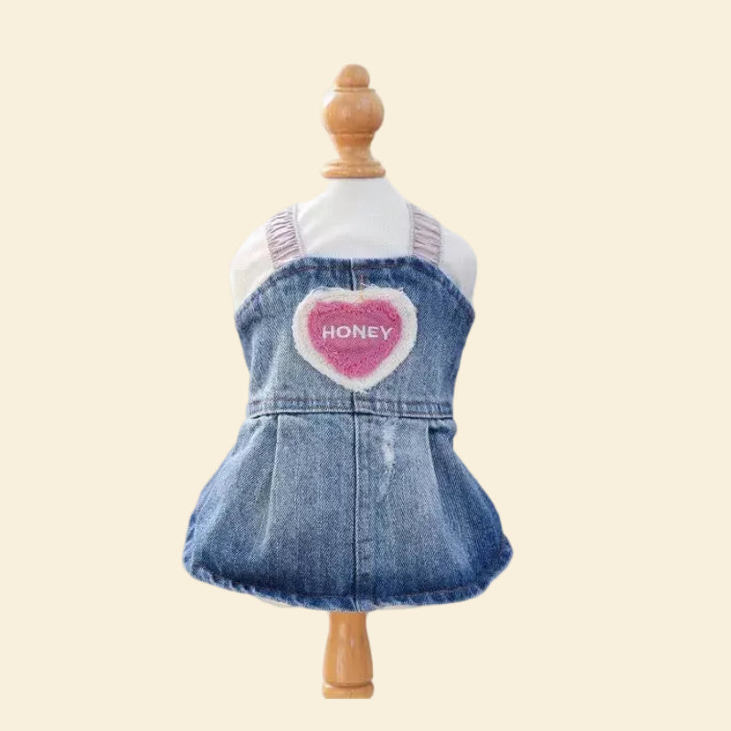 The Honey Heart Denim Dog Dress displayed on a pet mannequin, highlighting the expert tailoring of the ruffled skirt and perfectly faded vintage wash.
