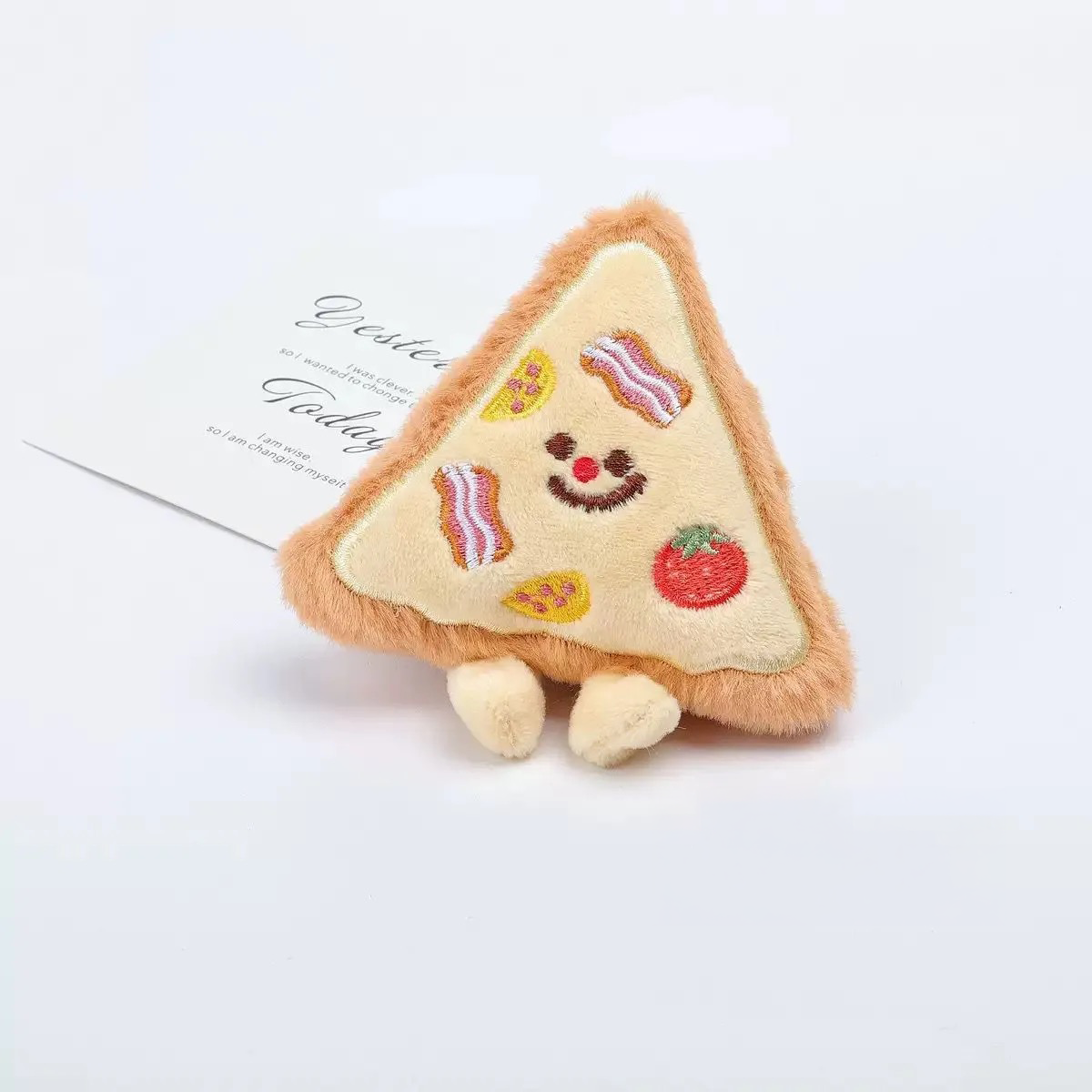 A classic triangular pizza slice plush toy with embroidered bacon and veggie toppings, designed for fetching and cuddling.