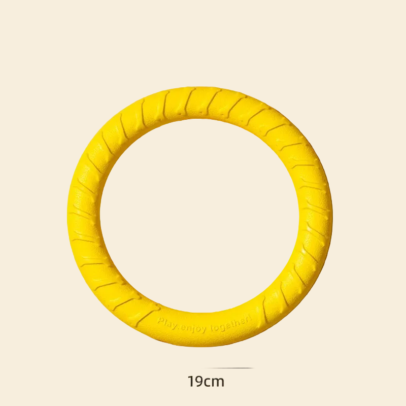 A top-down view of the vibrant yellow EVA dog pull ring against a warm background, featuring a dimension label of 19cm and highlighting the textured surface for easy grip and gum massage.
